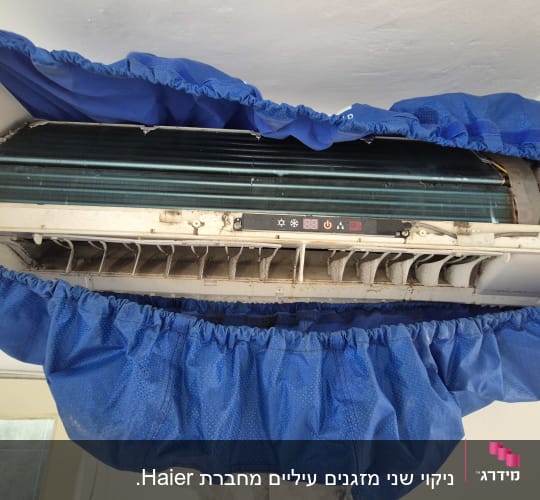 מזגן עם כיסוי כחול לתחזוקה וניקוי